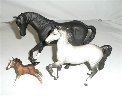Lot 80 - A Beswick matt glazed grey horse, a black horse and a foal (3)