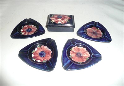 Lot 97 - A William Moorcroft anemone pattern box and cover and four ashtrays