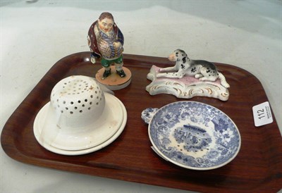 Lot 112 - Derby fat man, recumbent dog, blue printed egg drainer and an 'Antitannic' tea strainer with stand