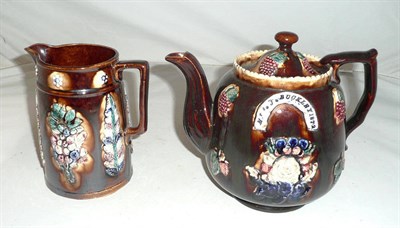 Lot 121 - A Measham teapot, 1871, applied with fruit and floral folk motifs and an arched appliqué to each