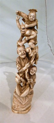 Lot 136 - A large marine ivory one piece carving of a group of four figures, signature to base