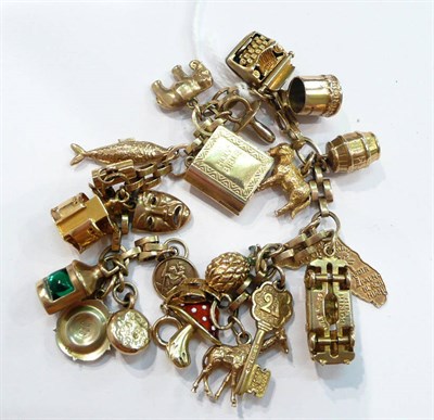 Lot 244 - A charm bracelet hung with twenty one charms, mostly 9ct gold