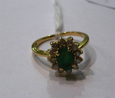 Lot 64 - An 18ct gold emerald and diamond cluster ring