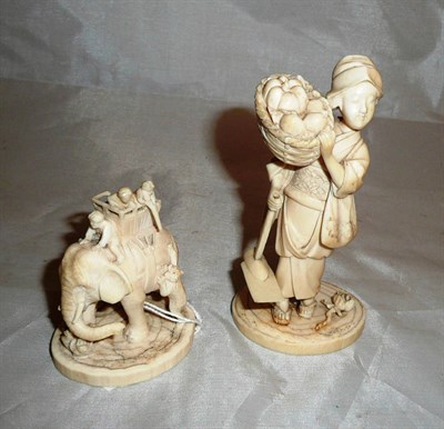 Lot 109 - Carved ivory figure of a fruit seller and another of an elephant group (2)