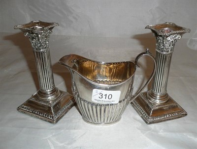 Lot 310 - Silver cream jug and a pair of loaded candlesticks