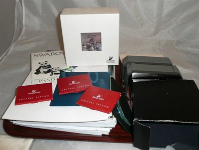 Lot 366 - Swarovski magazines and leaflets, cleaning kit, mirrored swarovski stands, three sets of...