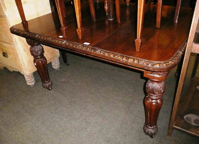 Lot 622 - A carved oak wind-action dining table and one leaf