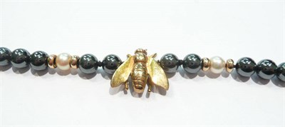 Lot 74 - A black pearl and gold bee necklace