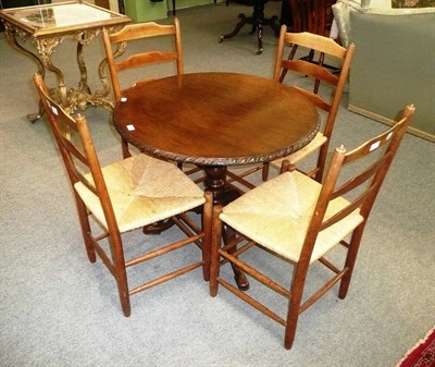 Lot 570 - Georgian tripod table later calved and four rush seat chairs