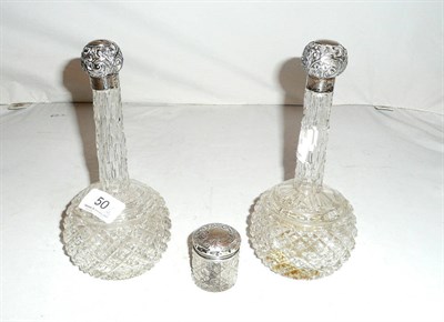 Lot 50 - A pair of cut glass scent bottles with silver covers and a silver-topped toilet jar