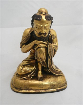 Lot 57 - A gilt bronze figure of a crouched lohan in Qing Dynasty style
