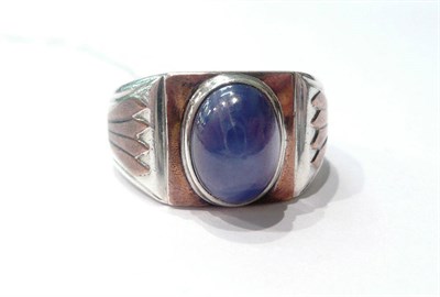 Lot 128 - A ring set with a star sapphire stone (possibly synthetic) in a mount stamped '950'