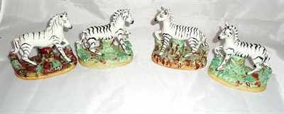 Lot 201 - Four Staffordshire pottery figures of zebras