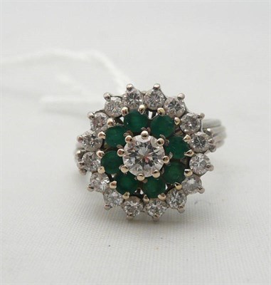 Lot 277 - An 18ct white gold diamond and emerald ring