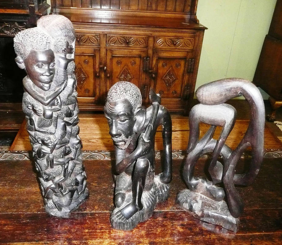 Lot 469 - A Makobe, Tanzania ebony carving of the tree of life, a similar figure of a crouching man and a...