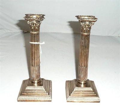 Lot 135 - A pair of Edwardian silver Corinthian column candlesticks, London 1903, loaded.