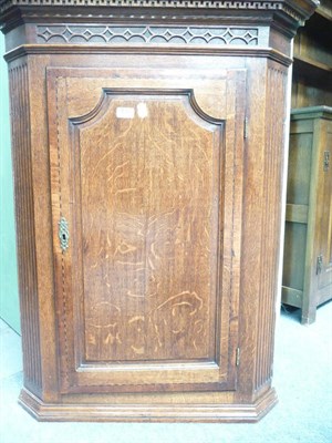 Lot 435 - A George III oak corner cupboard