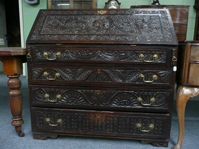 Lot 566 - A carved oak bureau