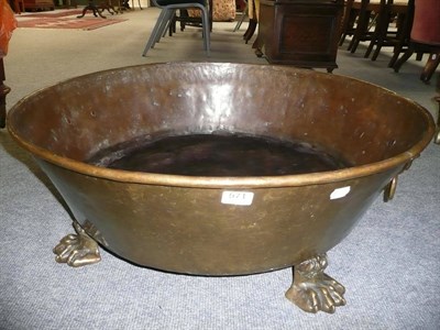 Lot 571 - A large brass bowl with lion mask handles and claw feet