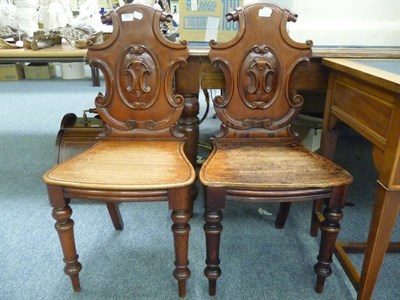 Lot 580 - A pair of mahogany hall chairs