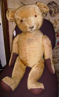 Lot 1014 - Large Yellow Plush Jointed Teddy Bear with brown felt paw pads, glass eyes, stitched nose, 77cms.