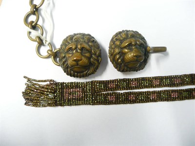 Lot 1138 - A Cut Steel Sautoir, with pink and green decoration, and A Lion Mask Cloak Clasp (2)