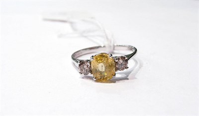 Lot 25 - A 14 carat white gold yellow sapphire and diamond ring