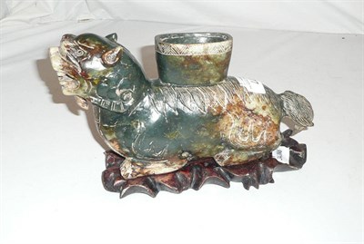 Lot 77 - A carved greenstone mythical beast on a hardwood stand