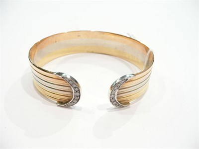 Lot 192 - An 18 carat three colour gold bangle set with diamonds