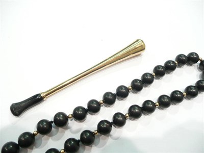 Lot 197 - A 9 carat gold cigarette holder and a strand of beads