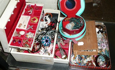 Lot 334 - A quantity of costume jewellery in a jewellery box, a box and a tin