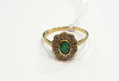 Lot 429 - An 18 carat gold emerald and diamond cluster ring