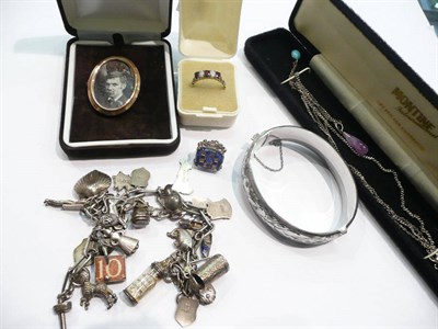 Lot 219 - A garnet and opal half hoop ring, a silver charm bracelet, a locket brooch, a silver bangle and two