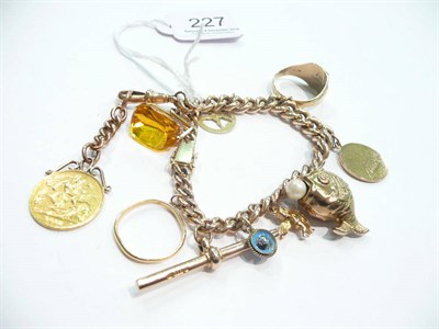 Lot 227 - A 9 carat gold charm bracelet hung with nine charms including a hard-mounted half sovereign