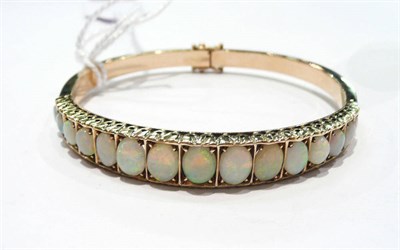 Lot 407 - A 9 carat gold opal line bangle