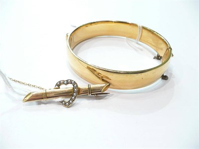 Lot 246 - A 9ct gold bangle, a bar brooch (2)