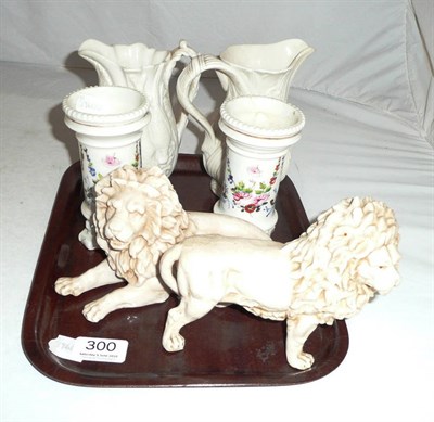 Lot 300 - Pair of continental figures of lions, two bisque jugs, and a pair of floral decorated spill vases