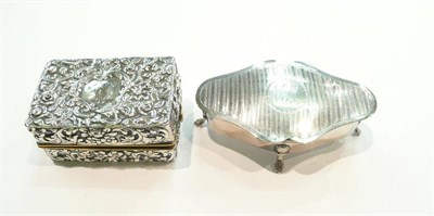 Lot 399 - Silver hinged lobed box and cover and an embossed silver mounted travel lamp (2)