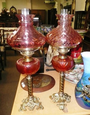 Lot 471 - A pair of cranberry glass oil lamps