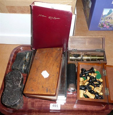 Lot 491 - A tray including two pairs of opera glasses, drawing instruments and chess pieces, small...