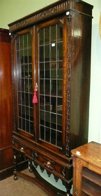 Lot 749 - Carved oak glazed bookcase on stand