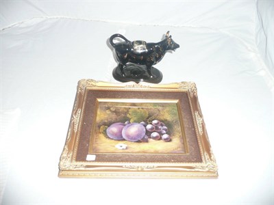 Lot 460 - Staffordshire pottery black glaze cow creamer, ceramic plaque painted with fruit by C Hughes