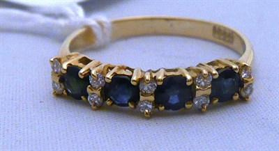 Lot 526 - Nine stone sapphire and diamond ring