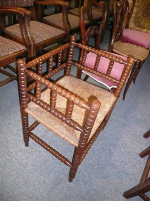 Lot 707 - A turned bobbin rush-seated armchair