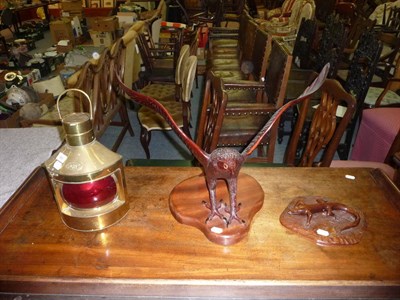 Lot 363 - A carved eagle and lizard on base together with a ships warning lamp 'port'