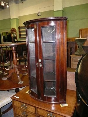 Lot 499 - A mahogany bow front glazed hanging corner cupboard and key