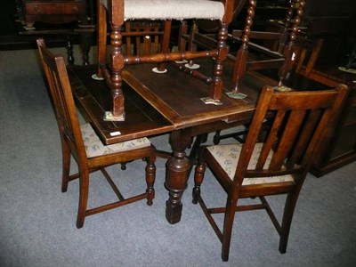 Lot 572 - An oak draw-leaf table and a set of four oak dining chairs and a single oak carver