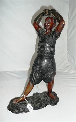Lot 167 - A Japanese bronzed figure of a warrior, standing barefoot, with arms raised above his head...