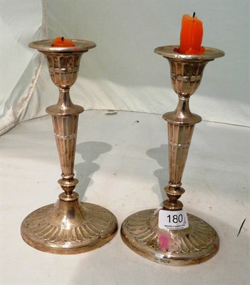 Lot 180 - A pair of George V silver candlesticks on fluted oval bases, Sheffield 1919, loaded