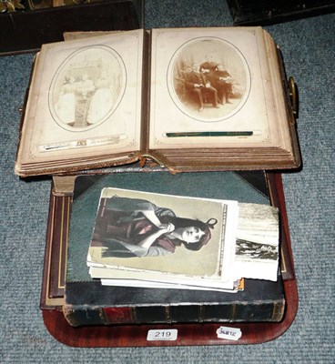 Lot 219 - A quantity of loose postcards, an empty postcard album, an album of [photographs and two books